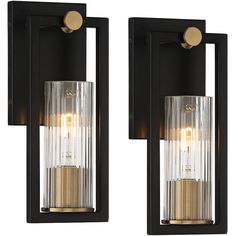 two lights that are on the side of a wall mounted fixture with glass panels and gold accents