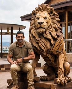 a man sitting next to a statue of a lion on top of a wooden platform