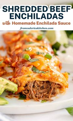 a white plate topped with meat and cheese covered enchilada next to sliced avocado