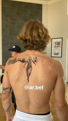 the back of a man with tattoos on his body