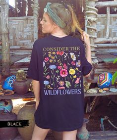 Calling all plant lovers and nature enthusiasts! This soft and comfy tee is the perfect way to show off your love for the wild. Featuring a beautiful wildflower design on the back and a "Wildflower Child" pocket on the front, this t-shirt is sure to make a statement. Wildflowers are a symbol of beauty, resilience, and hope. They thrive in the most challenging conditions, and their vibrant colors bring joy to the world. Just like wildflowers, we too can find strength and beauty in the midst of ad Botanical Style Relaxed Fit Graphic Print Shirt, Relaxed Fit Botanical Graphic Print Shirt, Botanical Relaxed Fit Graphic Shirt, Botanical Graphic Print Relaxed Fit Shirt, Botanical Plants Print Top With Relaxed Fit, Casual Summer Tops With Plant Details, Relaxed Fit Cottagecore Tops With Plant Print, Botanical Relaxed Fit Tops With Plant Print, Cottagecore Relaxed Fit Tops With Plant Print