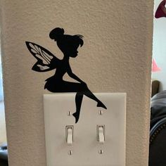 a light switch with a fairy silhouette on it