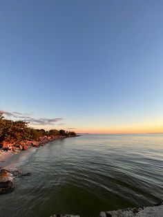 the beach is lined with trees and rocks