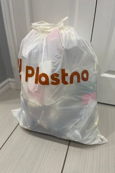 a plastic bag sitting on the floor in front of a door that says plastno