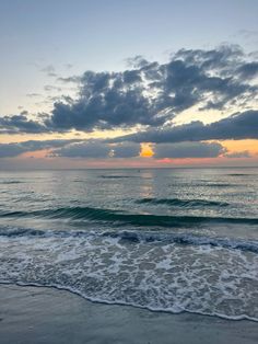 the sun is setting over the ocean with waves