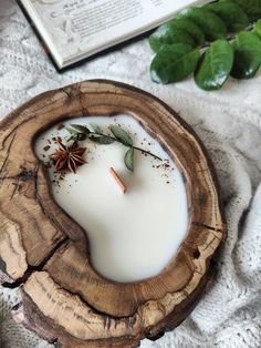 a candle that is sitting on top of a wood slice with some spices in it