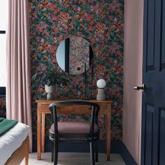 a room with a chair, mirror and wallpaper on the walls in pink tones