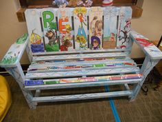 a bench made out of children's books with the word peace painted on it