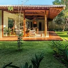 an outdoor living area in the middle of a yard with grass and trees around it