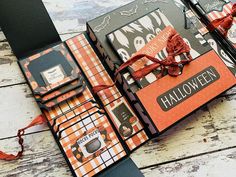 an orange and black halloween themed scrapbook on a wooden table with scissors, tape and other items