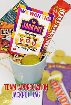 a cup filled with candy and candies sitting on top of a table next to a sign that says we won the jackpot