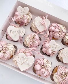 a box filled with lots of cupcakes covered in pink frosting and hearts