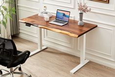 a laptop computer sitting on top of a wooden desk next to a black office chair