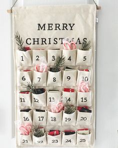 a christmas calendar hanging on a wall with stockings and candies in the pockets