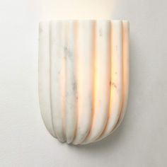 a white wall mounted light fixture with marble design