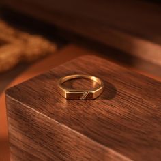 a gold ring sitting on top of a wooden box