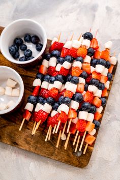 fruit and marshmallow skewers on a cutting board