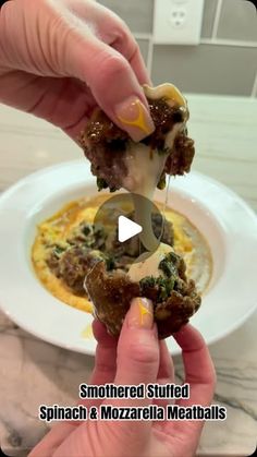 someone is dipping something into a bowl of soup with meatballs and cheese on it