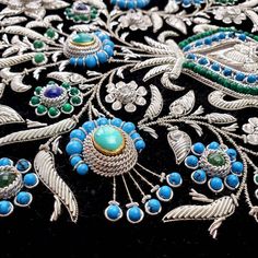 Visually stunning, elaborate, opulent three dimensional floral tapestry hand embroidered with metallic white silver colored flowers and inlaid with turquoise, malachite, lapis lazuli stones on black velvet. Crowned with an iridescent moonstone that picks up the blue and green colors. Extraordinary gemstone wall art. So many textures and finishes!! Shine a light on it to make the gemstones and metallic finish glow. In daylight, the flowers and leaves appear whitish silver, in nighttime they appea Traditional Silver Embroidered Jewelry, Gemstone Embroidery, Couture Beading, Kaftan Designs, Shine A Light, Embroidery Works, Types Of Gifts, Hand Embroidery Flowers, Colored Flowers