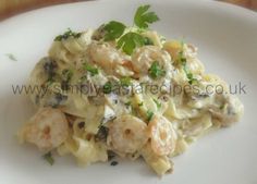 a white plate topped with pasta and shrimp