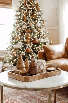 a living room with a christmas tree and coffee table in front of the couches