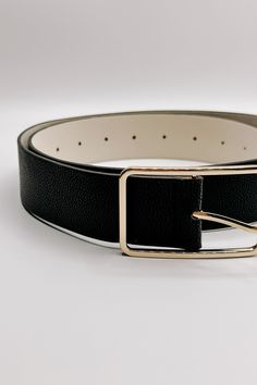 The Lydia Black Faux-Leather Belt is the perfect understated accessory for a polished look. Crafted from smooth black faux leather, this belt exudes minimalist sophistication. Its sleek design is finished with a thin rectangular gold buckle, adding just the right amount of shine. Ideal for pairing with jeans, trousers, or dresses, the Lydia belt effortlessly complements both casual and refined outfits, offering versatility and timeless style. Length: 41" Clear Purses, Faux Leather Purse, Studded Necklace, Travel Dress, Faux Leather Belts, Jumpsuit Shorts Rompers, Bar Earrings, Anklet Jewelry, Leather Belts