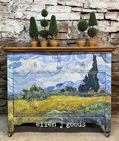 a painted dresser with potted plants on top