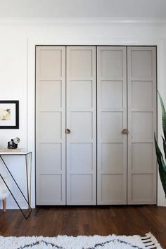 a room with white closet doors and a rug on the floor in front of it