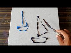 someone is drawing something with colored pencils and watercolors on paper that looks like sailboats