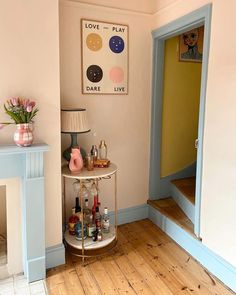 a small bar cart in the corner of a room next to a fire place and fireplace