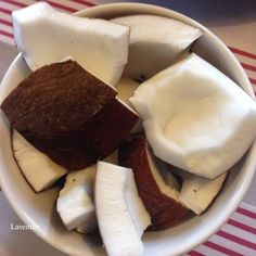 a white bowl filled with lots of different types of food on top of a red and white table cloth