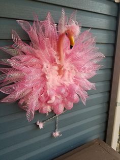 a pink flamingo hanging on the side of a building