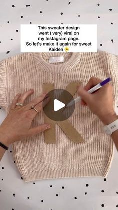 someone is cutting out a paper t - shirt with scissors