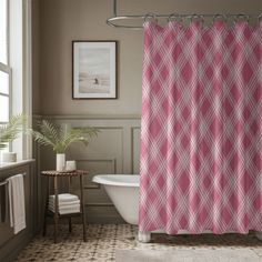 a bathroom with a pink shower curtain next to a bath tub