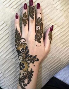 a woman's hand with henna tattoos on it