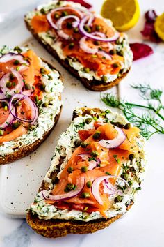 three pieces of bread with salmon and onions on them