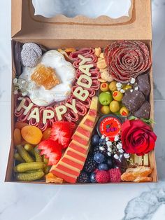 a box filled with lots of different types of candies and fruit on top of a table