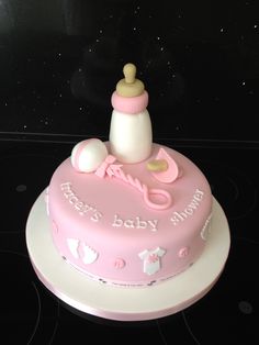 a pink baby shower cake sitting on top of a stove