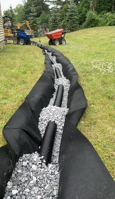 a large pipe laying on top of a lush green field