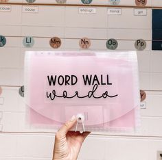 a person holding up a sign that says word wall