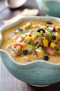 a blue bowl filled with soup on top of a wooden table