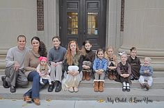 a group of people that are sitting on the steps together in front of a building