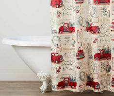 a shower curtain with red trucks and trees on it in front of a bathtub