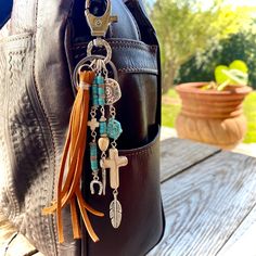 a purse with some charms hanging from it's front and side pockets on the back