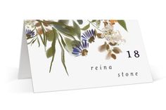 a white card with blue flowers and greenery on it, reads reina stone