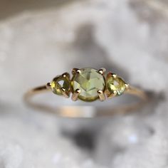 - Rose Cut peridot measures 3mm and 5mm  - Round band measures 1.2mm - Available in solid 10K or 14K gold - Peridot is natural   Processing times -  Current processing time is 2 - 4 weeks.  Each Item is handmade to order with love and care! In Stock Items -  Contact Liesel Love with any rush order questions, or to see if we have anything ready made and in stock.  Returns -  Liesel Love does take returns for a refund or exchange. A re-stocking fee of 15% will be applied to all fine jewelry returns. Items must be shipped back and received before refund is made. Returns must be notified within 7 days after tracking states delivered (exceptions are made during the holiday season). The customer is responsible for return shipping. Be sure to include any original packaging and invoices/receipts s Gold Peridot Ring, Ring Green Stone, Peridot Engagement Rings, Ring Three Stone, Three Stone Ring, August Birthstone, Hammered Gold, Ring Light, Peridot Ring