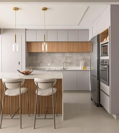 a kitchen with two bar stools next to an oven