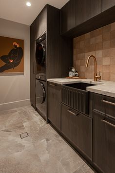 a washer and dryer in a room with tile flooring on the walls