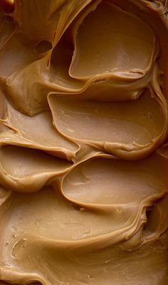 a pan filled with chocolate frosting sitting on top of a table