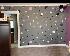 a room with purple and white polka dots on the wall